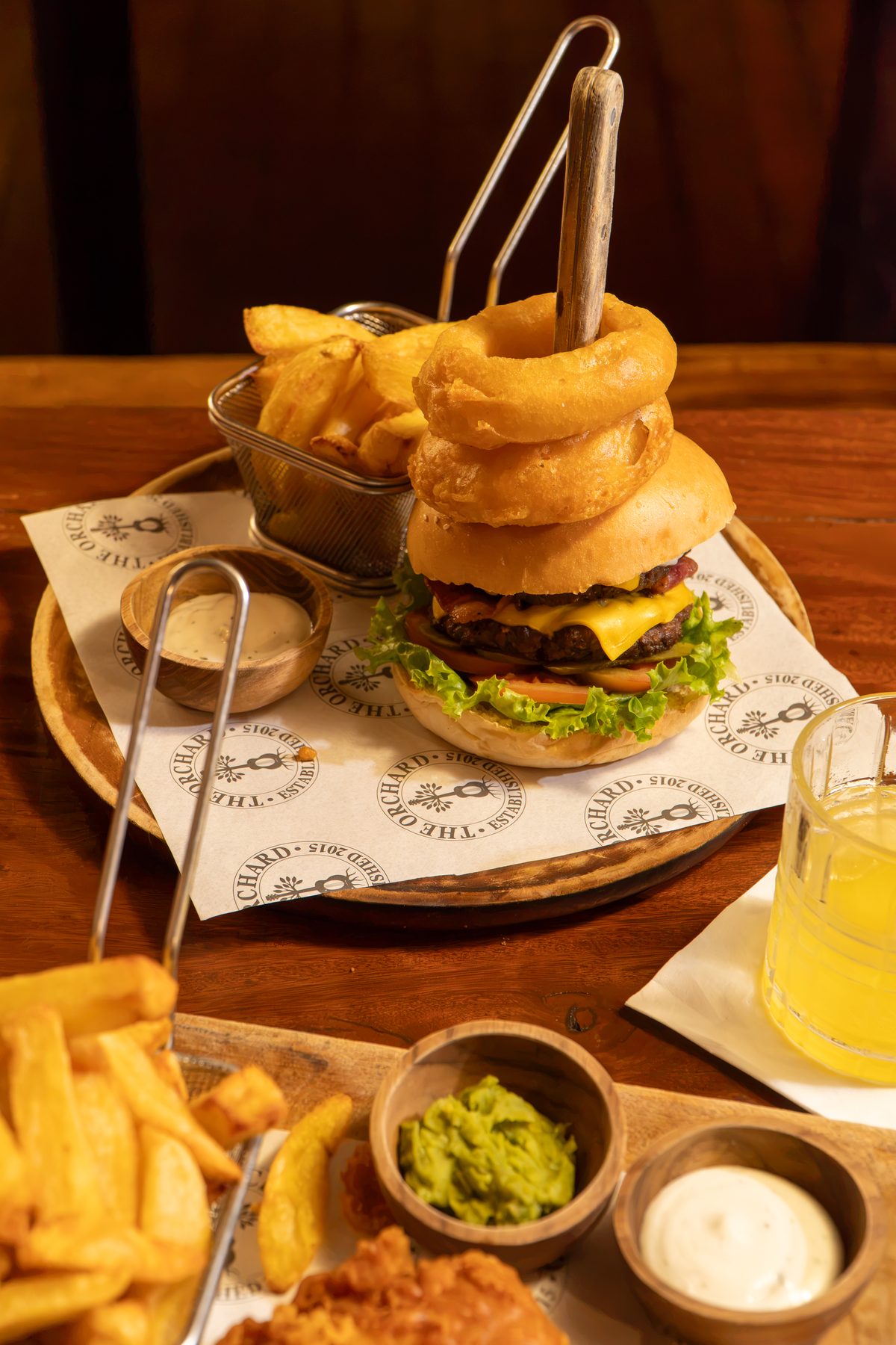 Loaded cheeseburger with onion rings and chips at The Orchard