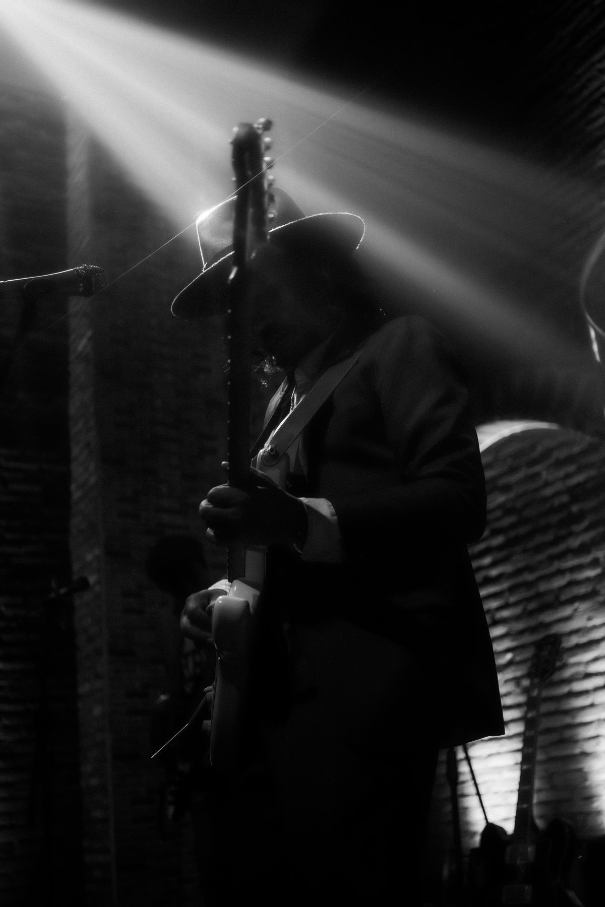 Guitarist silhouetted on stage at The Orchard